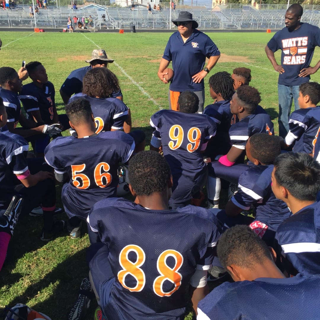 football team and coach on the field