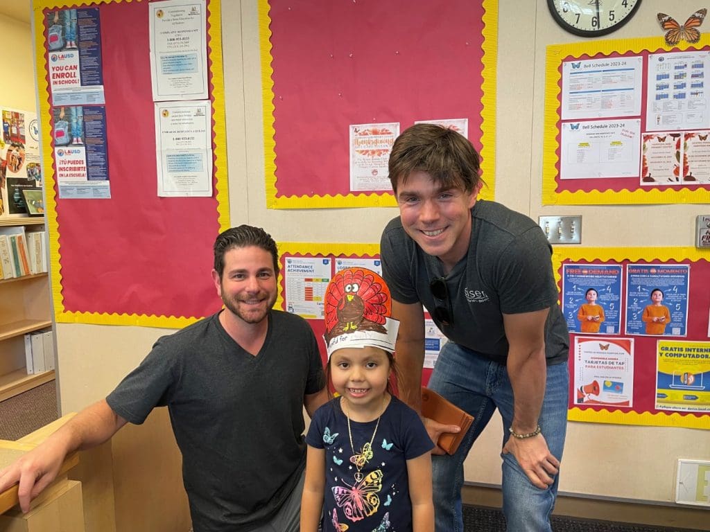 two volunteers and a child at the Thanksgiving event