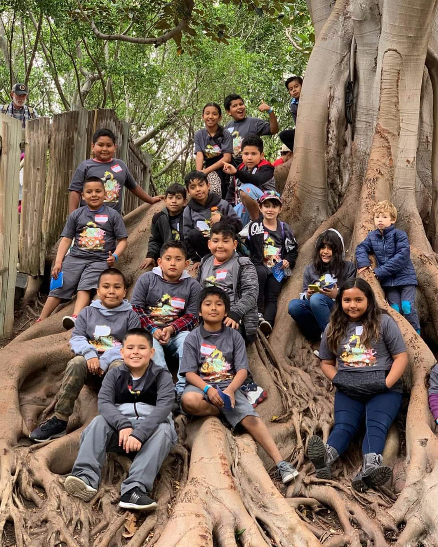 donate we benefit children. a group of kids sitting in a large tree